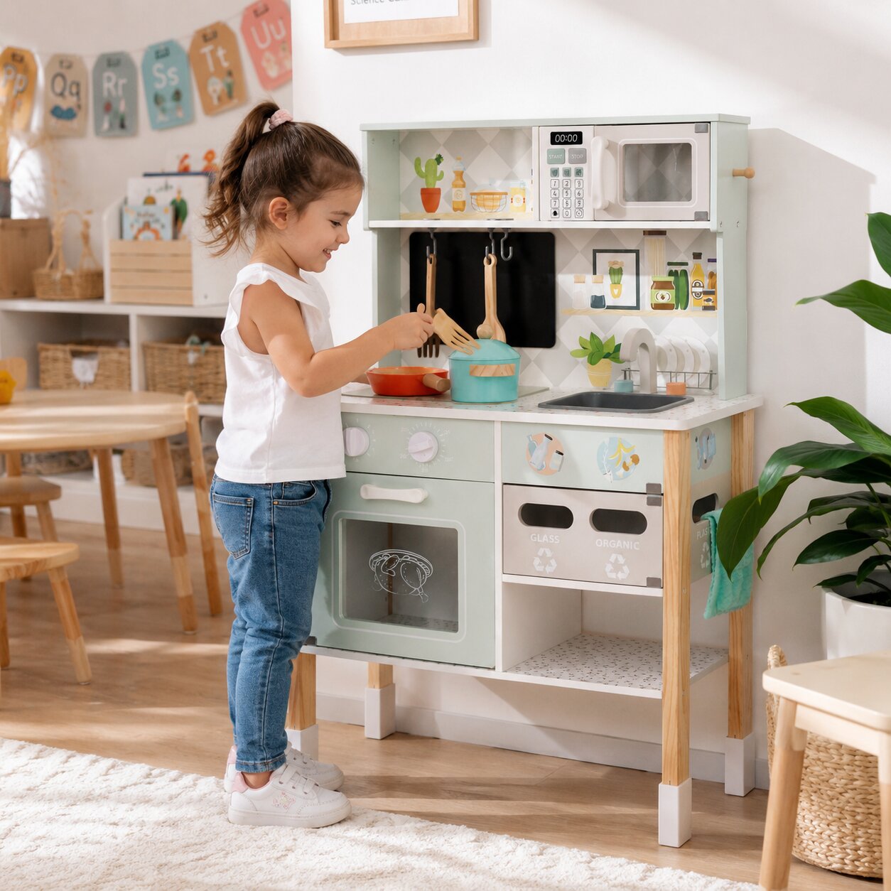 Момиче готви на детска дървена кухня GINGER HOME с котлон, тенджера, тиган, мивка и микровълнова